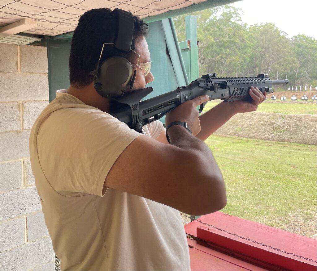 Man holding gun at firearms range to shoot clay target