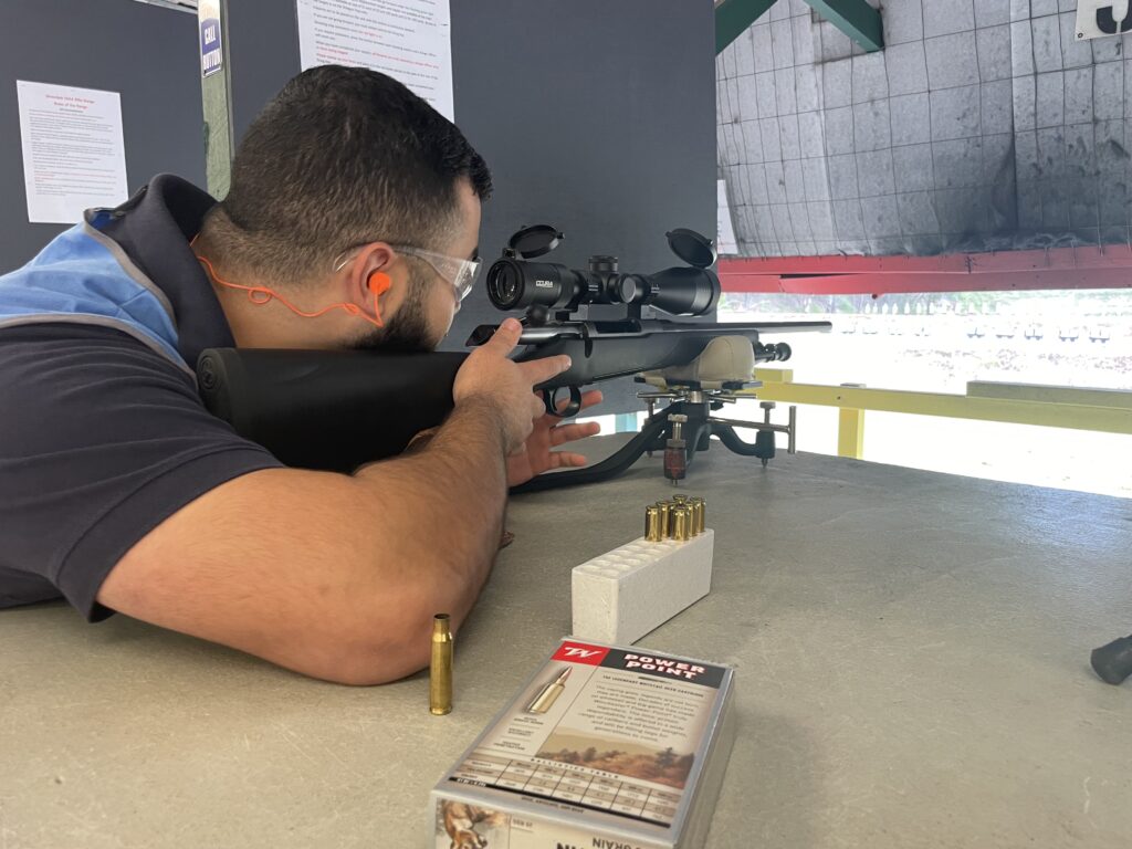 Man scoping gun on firearm bench